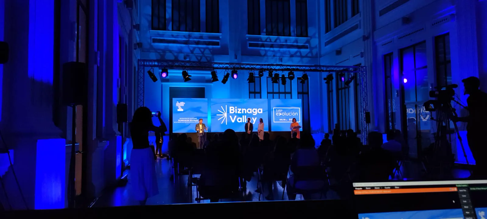 Escenario con pantalla central y público en un congreso corporativo