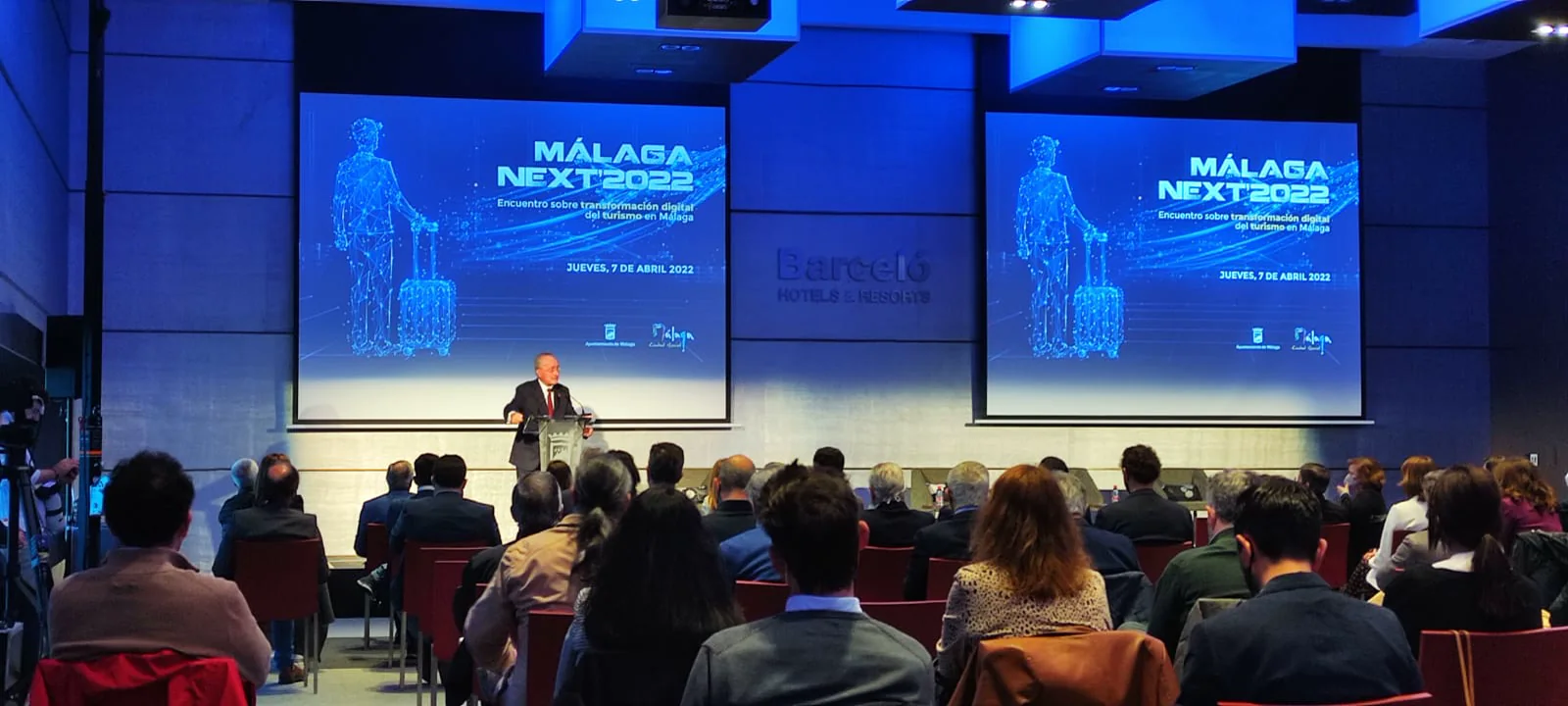 Público frente a una gran pantalla en un congreso profesional